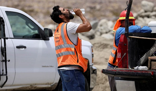 A contruction worker drinks water in temperatures that have reached well above triple digits in Palm Springs, California, U.S. July 20, 2022 (Reuters)