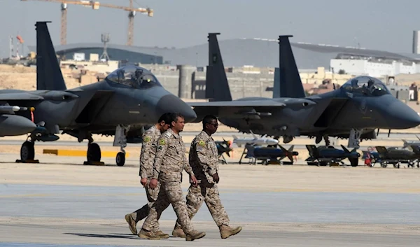 Saudi army officers walk past US-made F-15 fighter jets displayed at King Salman air base in Riyadh, on 25 January 2017. (AFP)