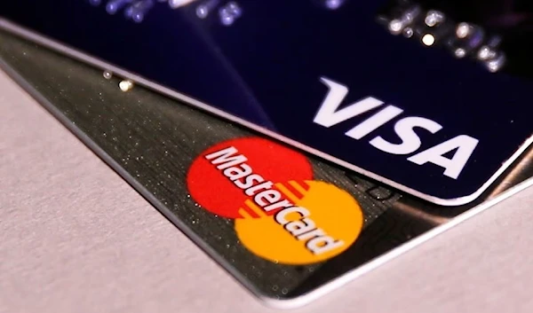 A Visa credit card placed on tip of a Mastercard credit card, 9 June 2016. (Reuters)