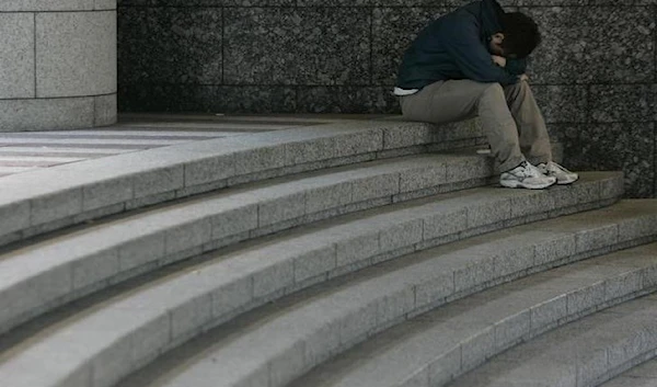 A man sits hunched over on a staircase in Tokyo November 17, 2008. (Reuters)