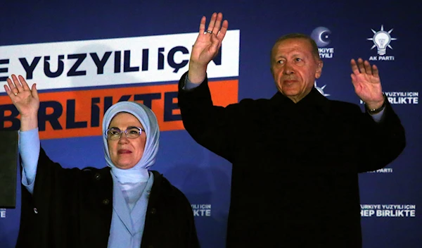 Turkish President Recep Tayyip Erdogan, right, and his wife Emine gesture to supporters at the party headquarters, in Ankara, Turkey, early Monday, May 15, 2023 (AP Photo/Ali Unal)