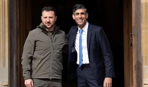 British Prime Minister Rishi Sunak wraps his arm around Ukrainian President Volodymyr Zelenksy at Chequers, Alylesbury, England, 15 May 2023. (Reuters)