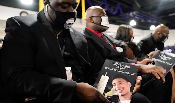 Brandon Williams, nephew of George Floyd, displays the program for the funeral services of Daunte Wright at Shiloh Temple International Ministries in Minneapolis, April 22, 2021 (AP)