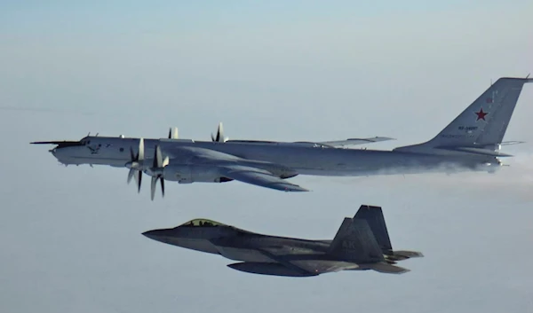 In this March 9, 2020, photo released by the North American Aerospace Defense Command, a Russian Tu-142 maritime reconnaissance aircraft, top, is intercepted near the Alaska coastline.