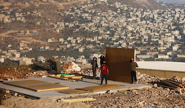 Illegal Israeli settlers construct a structure in “Givat Eviatar”, Israeli settler outpost, near the Palestinian village of Beita in the Israeli-occupied West Bank June 23, 2021. (Reuters)