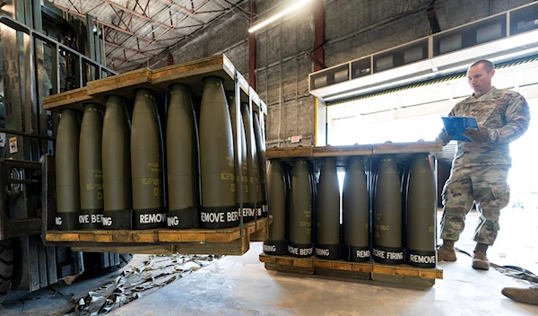 U.S. Air Force Staff Sgt. Cody Brown, right, with the 436th Aerial Port Squadron, checks pallets of 155 mm shells ultimately bound for Ukraine, April 29, 2022, at Dover Air Force Base, Del. (AP)