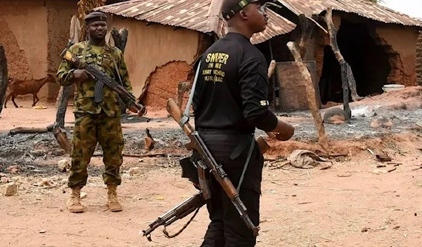 Security personnel stand guard in the Kukawa Village in the Kanam Local Government Area of the Plateau state on April 12, 2022 after resident’s houses were burnt down during an attack by bandits. (AFP)