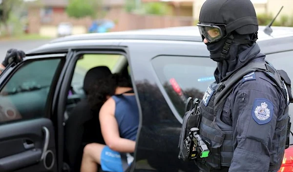 Heavily armed police officers detain a man during early morning raids in western Sydney, Australia, December 10, 2015, in this handout courtesy of New South Wales (NSW) Police (Reuters)