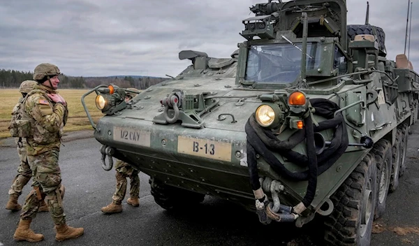 Soldiers of the 2nd Cavalry Regiment stand next to a Stryker combat vehicle in Vilseck, Germany, Wednesday, Feb. 9, 2022 (AP Photo/Michael Probst, File)