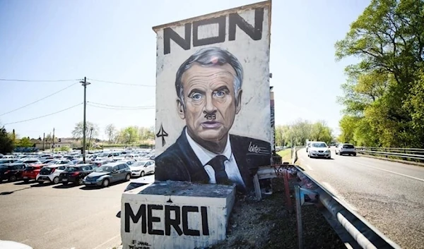 A graffiti image by the artist Lekto, depicting French President Emmanuel Macron with 49.3 written as a moustache and the words "No thanks" in Avignon, southeastern France, on 3 April, 2023. (AFP)