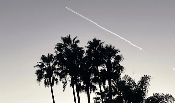 A SpaceX Falcon 9 rocket streaks across the sky, as seen from Pasadena, after launching from Vandenberg Space Force Base, California, carrying 53 Starlink satellites into orbit, October 27, 2022 (AP)