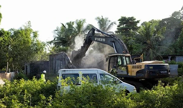 An excavator demolishes an informal settlement in Longoni, Mamoudzou, on the island of Mayotte on April 27, 2023. (AFP)