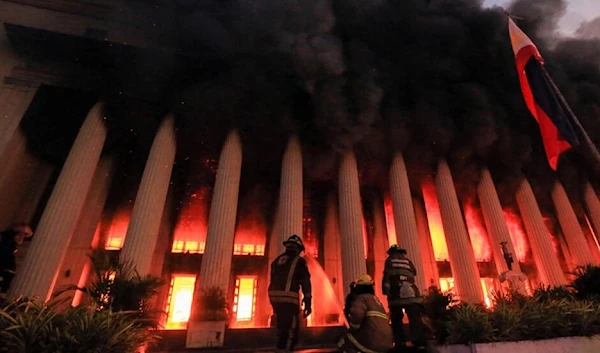 Firefighters work on putting out the flames which scorched through the Manila Post Central Office, Manila, Philippines, 22 May 2022. (AFP via STR)