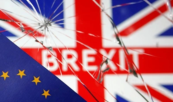 A flag of the EU is placed over broken glass and a flag of the UK with 'BREXIT' printed in its center, January 31 2020. (Reuters)