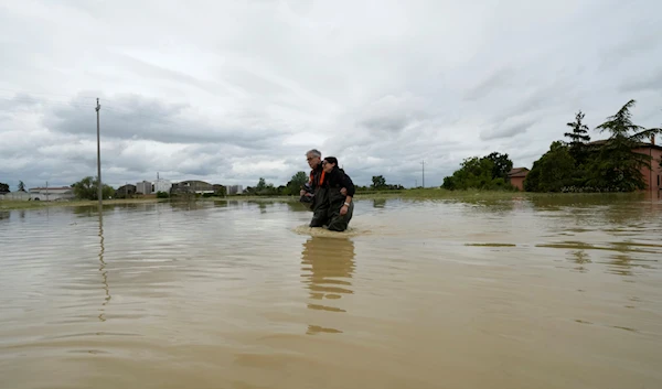 A couple walk in a flooded road of Lugo, Italy, Thursday, May 18, 2023. (AP)