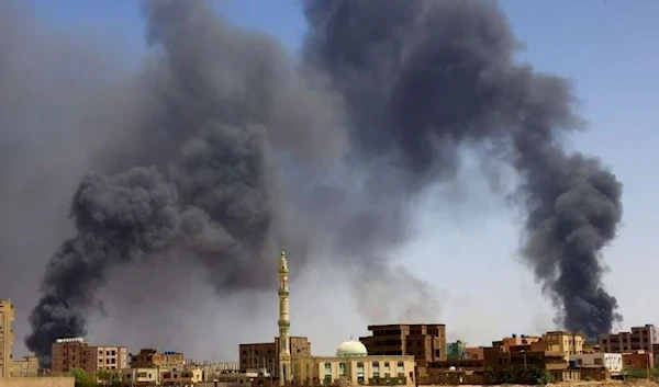 A man walks while smoke rises above buildings after aerial bombardment, during clashes between the paramilitary Rapid Support Forces and the army in Khartoum North, Sudan, May 1, 2023. (Reuters)