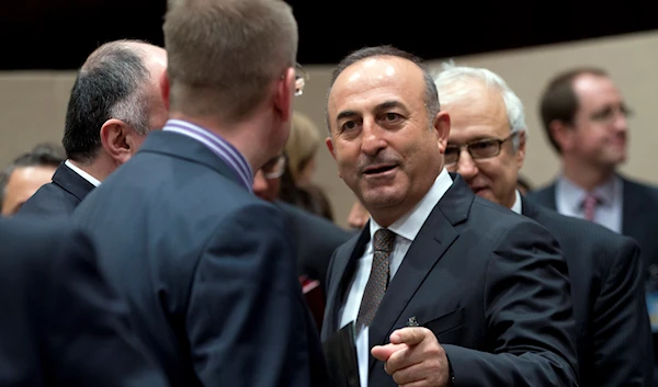 Turkish Foreign Minister Mevlut Cavusoglu, center, speaks with Latvian Foreign Minister Edgars Rinkevics, second left, during a round table meeting of Resolute Support at NATO headquarters in Brussels on Tuesday, Dec. 1, 2015. (AP)