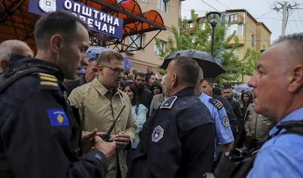 Aleksandar Arsenijevic, local politician, talks to police officers in the town of Zvecan, Kosovo, Friday, May 26, 2023.  (AP)