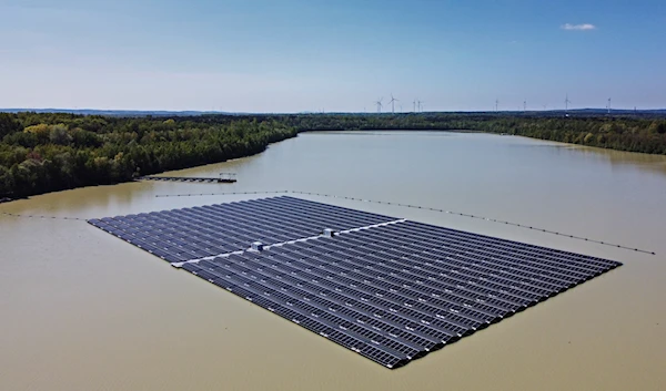 Solar panels on Germany's biggest floating photovoltaic plant produce energy on a lake in Haltern, Germany, on May 3, 2022 (AP)