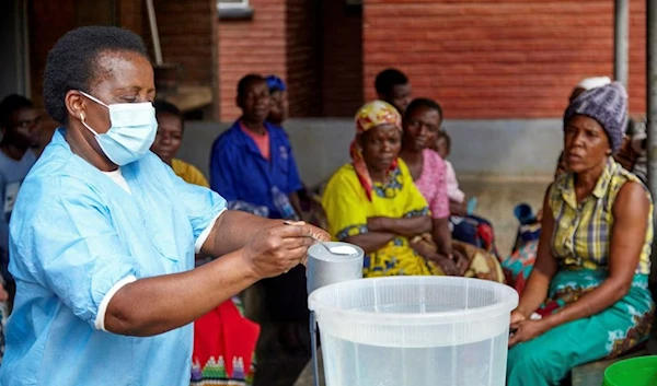 Violett Motta, a health surveillance assistant in Malawi, mixes chlorine with water to disinfect it at a health centre in response to the latest cholera outbreak in Blantyre, Malawi, November 16, 2022. (Reuters)