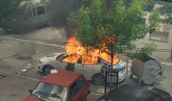 In this grab taken from video, a view of a car set on fire as KFOR soldiers clash with Kosovo Serbs in the town of Zvecan, northern Kosovo, May 29, 2023 (AP)