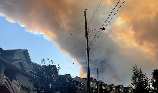 [1/3] Smoke from the Tantallon wildfire rises over houses in nearby Bedford, Nova Scotia, Canada, May 28, 2023 (Reuters)