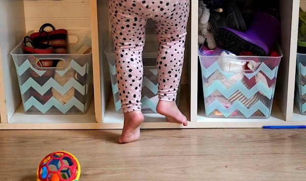 A preschooler gets up on her toes to reach into her cubby at a preschool center in Mountlake Terrace, Washington (AP)