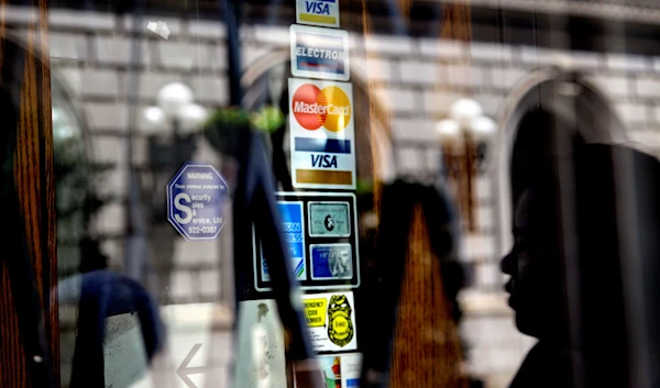 n this July 18, 2012 file photo, credit logos are seen on a downtown storefront as a pedestrian passes in Atlanta. (AP)