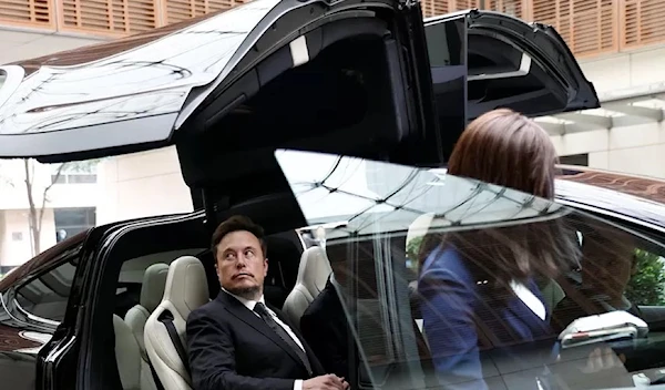 Elon Musk in a Tesla as he leaves a hotel in Beijing on Wednesday (Reuters)