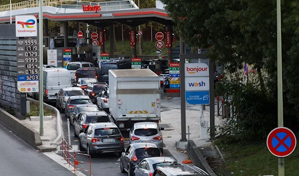 Cars queue to fill their fuel tanks at a Total petrol station in Paris, France, October 8, 2022. (Reuters)