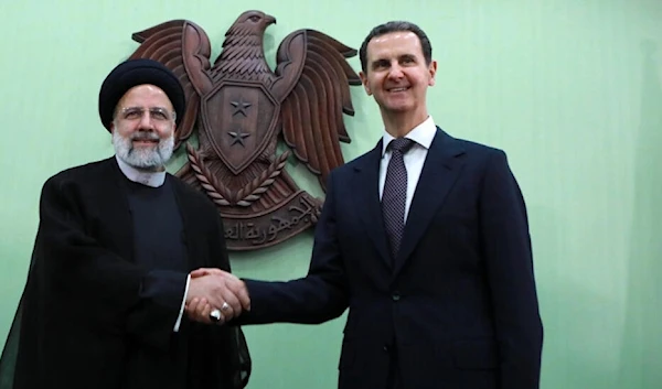 Syria's President Bashar al-Assad, on the right, with his Iranian counterpart Ebrahim Raisi in Damascus on May 3, 2023. (AFP)