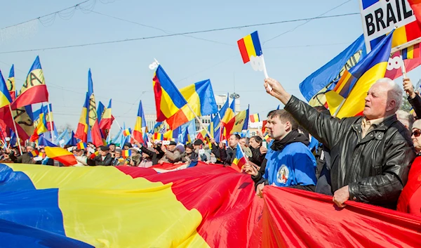 Moldovan and Romanian citizens participate at a rally to mark the 100th anniversary of the unification of Moldova with Romania, in the Great National Assembly Square in Chisinau, Moldova, 25 March 2018 (EPA)