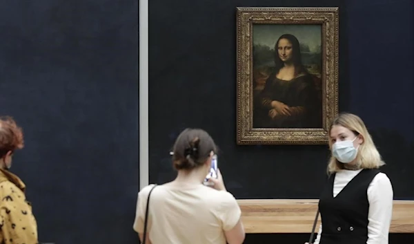 Visitors pose in front of Leonardo da Vinci's Mona Lisa in the Louvre museum, Wednesday, May, 19, 2021 in Paris. (AP)