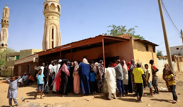 People gather to get bread during clashes between the paramilitary Rapid Support Forces and the army in Khartoum North, Sudan, April 22, 2023 (Reuters)