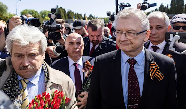 Russia's Ambassador to Poland Sergey Andreev, right, speaks to reporters in front of a memorial site to Red Army soldiers in Warsaw, Poland, Tuesday May 9, 2023. (AP)