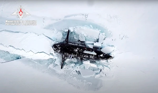 In this handout photo taken from footage released by Russian Defense Ministry Press Service on March 26, 2021, a Russian nuclear submarine breaks through the Arctic ice during military drills at an unspecified location (AP)