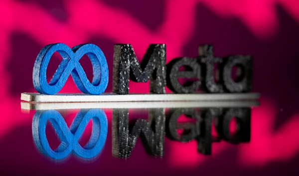 A 3D printed Meta logo is placed in front of a stock graph, November 2 2021. (Reuters)