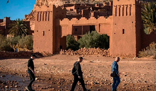 Tourists walk past the Kasbah (ancient fortress) of Ait-Ben-Haddou near Ouarzazate south of Morocco's High Atlas mountains on January 27, 2020. (AFP)