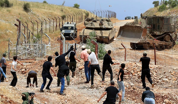 Lebanese protesters throw stones at Israeli troops on the outskirts of the Lebanese village of Kfar Chouba, south Lebanon, June 9, 2023 (AP)