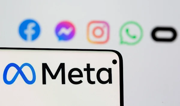 The Meta logo is displayed on a phone screen in front of the logos of the company's apps, October 28 2021. (Reuters)