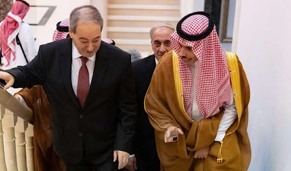 Syrian Foreign Minister Faisal Mekdad (L) walks up a stairway with Saudi Foreign Minister Prince Faisal bin Farhan (R) in Jeddah, April 12, 2023. (AFP)