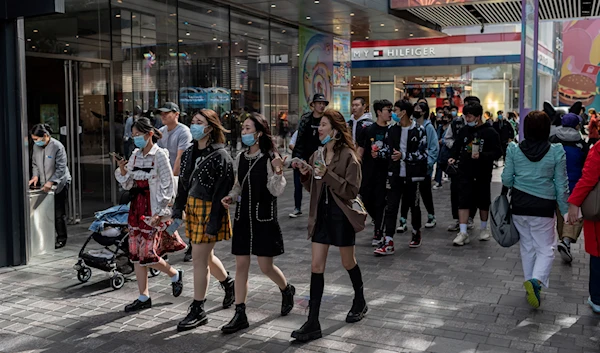 Shoppers walk outside a shopping mall complex during China's “Golden Week” holiday in Beijing, China, October 2 2020. (AFP)