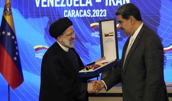 Iranian President Ebrahim Raisi shakes hands with Venezuelan President Nicolas Maduro after receiving the oRder of Libertador y Libertardora de Primera Clase, at the Miraflores Presidential Palace in Caracas, Venezuela, June 12 2023. (AP)