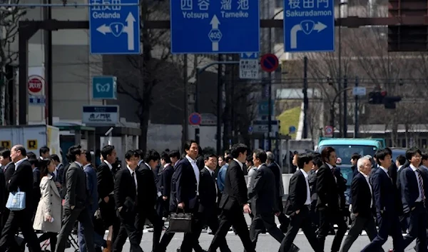 White-collar workers walk on a crosswalk in Tokyo on April 3, 2017 (AFP)