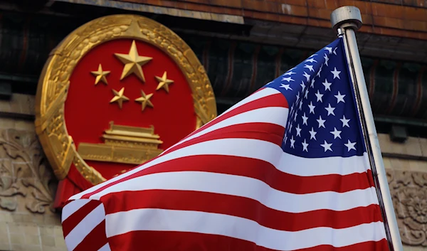 An American flag is flown next to the Chinese national emblem during a welcome ceremony at the Great Hall of the People in Beijing, Nov. 9, 2017 (AP)