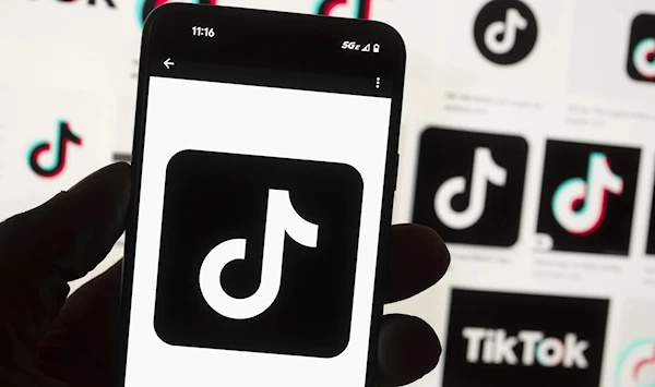 The TikTok logo is displayed on a smart phone held in front of multiple logos, Boston, US, October 14 2022. (AP)