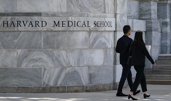 =Pedestrians walk towards the Harvard Medical School, Thursday, Aug. 18, 2022, in Boston. (AP)