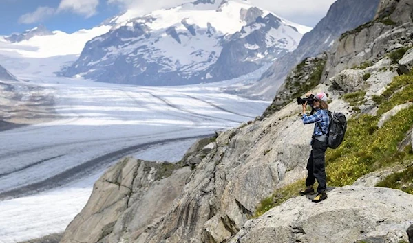 In this July 21, 2020 file photo, Swiss photographer David Carlier takes photographs of the Swiss Aletsch glacier, the longest glacier in Europe, in Fieschertal, Switzerland. (AP)