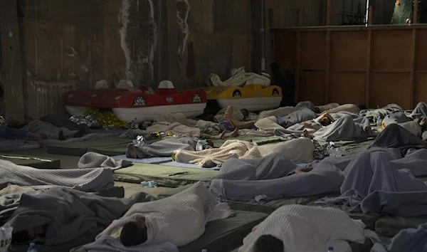 Survivors of a shipwreck sleep in a warehouse at the port in Kalamata town, about 240 kilometers (150 miles) southwest of Athens, Wednesday, June 14, 2023. (AP)