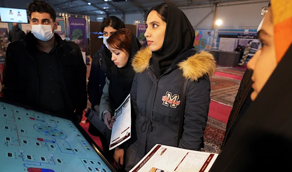 Students listen to a technician while visiting an exhibition of the country's nuclear achievements, in Tehran, Iran, Wednesday, Feb. 8, 2023 (AP Photo/Vahid Salemi)